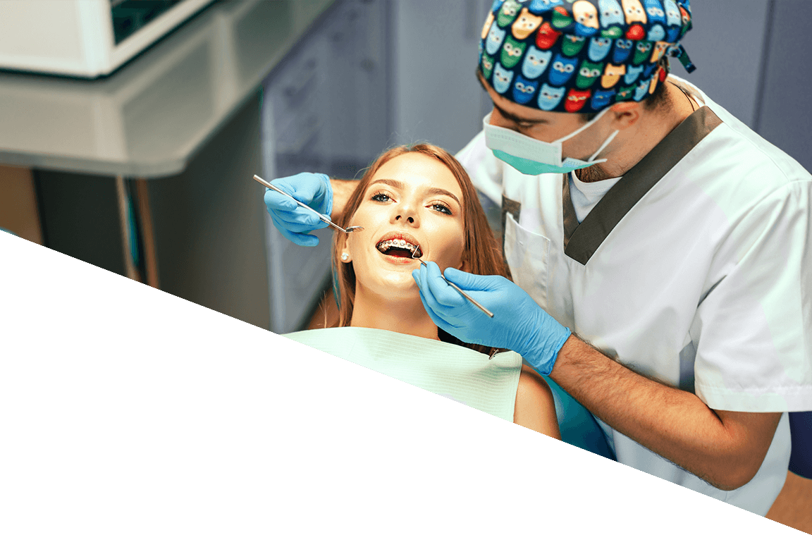 An orthodontist works with a patient wearing braces.